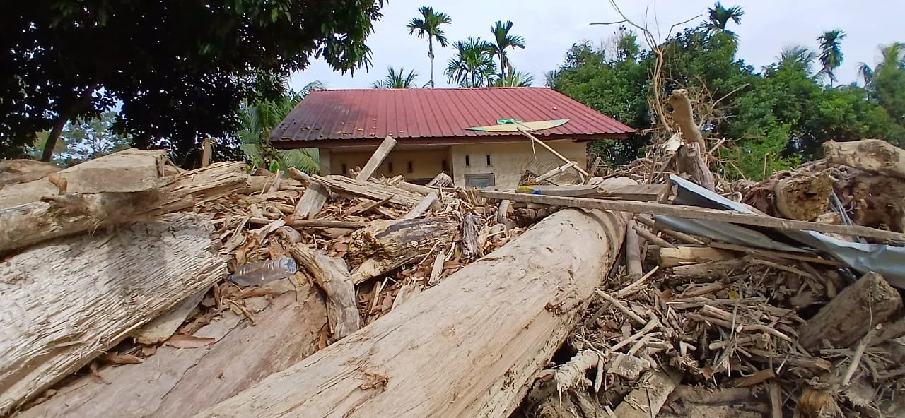 Foto: Tampak tumpukan kayu yang terbawa arus menghantam dan menumpuk di halaman rumah warga di wilayah pedalaman kecamatan Langkahan Aceh Utara, Selasa (3/1/foto/RR)