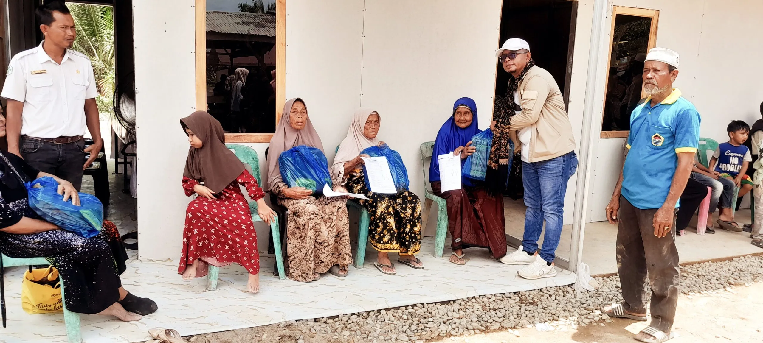 Aktivis Sosial Aceh, juga mentor Global Ehsan Relief, Akmal Daud menyerahkan sembako Untuk lansia, di sela selah kegiatan pengobatan gratis. (photo : alman)