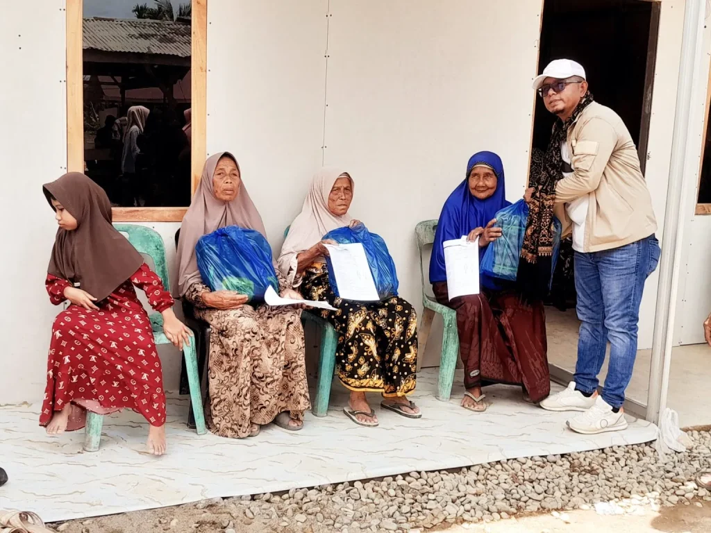 Aktivis Sosial Aceh, juga mentor Global Ehsan Relief, Akmal Daud menyerahkan sembako Untuk lansia, di sela selah kegiatan pengobatan gratis. (photo : alman)