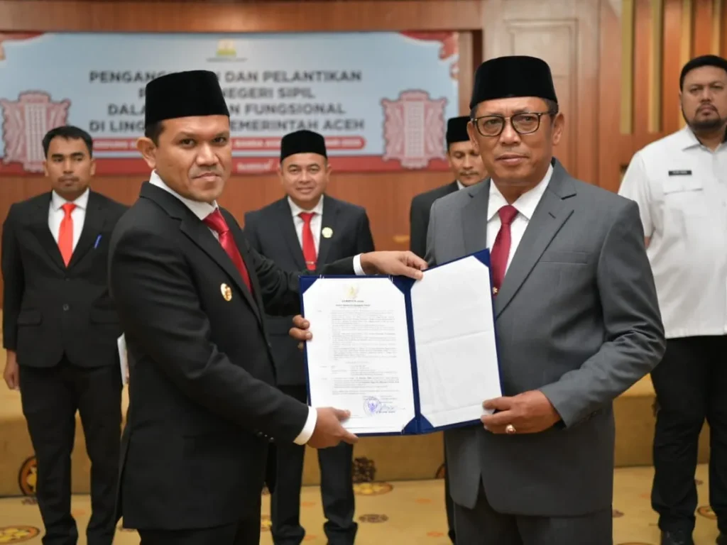 Foto: Wakil Gubernur Aceh, Fadhlullah, menyerahkan surat keputusan (SK) penunjukan Alhudri sebagai Pelaksana Tugas (Plt) Sekretaris Daerah Aceh menggantikan Muhammad Diwarsyah, di Gedung Serbaguna Kantor Gubernur Aceh, pada Rabu, (19/2/2025).