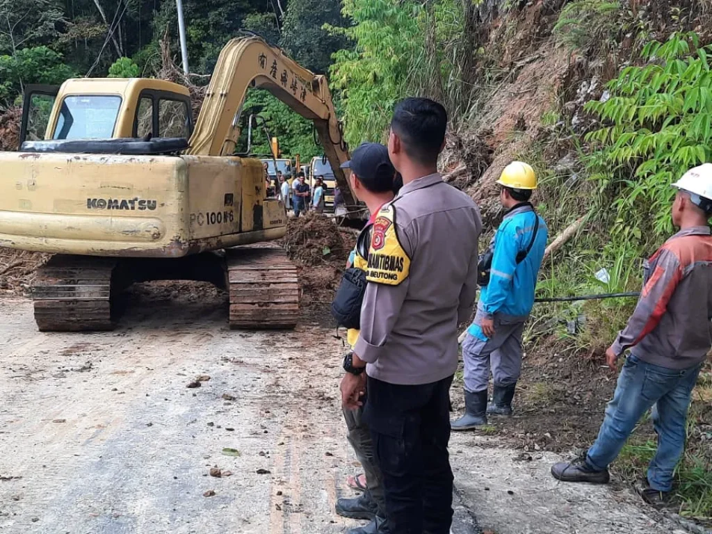 Foto: Polisi beserta warga bergotong royong membersihkan tanah longsor