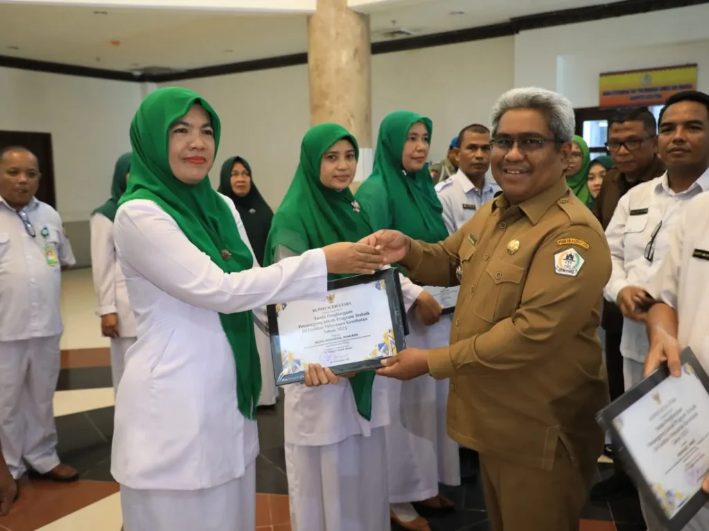 Foto: Penjabat Bupati Aceh Utara. menyerahkan Penghargaan kepadda Nakes karena karena dinilai sukses sebagai penanggung jawab program terbaik di Puskesmas masing-masing.