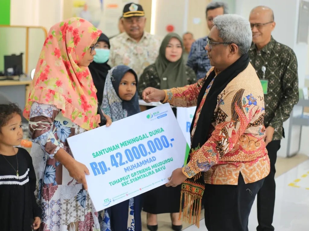 Foto: enjabat (Pj) Bupati Aceh Utara, Dr. Drs. Mahyuzar MSi secara simbolis menyerahkan santunan kematian dan beasiswa dari BPJS Ketenagakerjaan Lhokseumawe kepada sejumlah keluarga aparatur gampong yang meninggal dunia