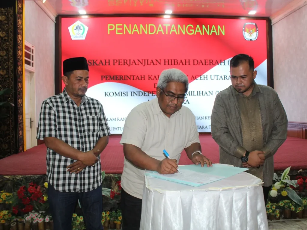 Foto: Pj Bupati Aceh Utara, Mahyuzar dan Ketua KIP Aceh Utara, Hidayatul Akbar SH  Menandatangani NPHD di pendopo Bupati Aceh Utara