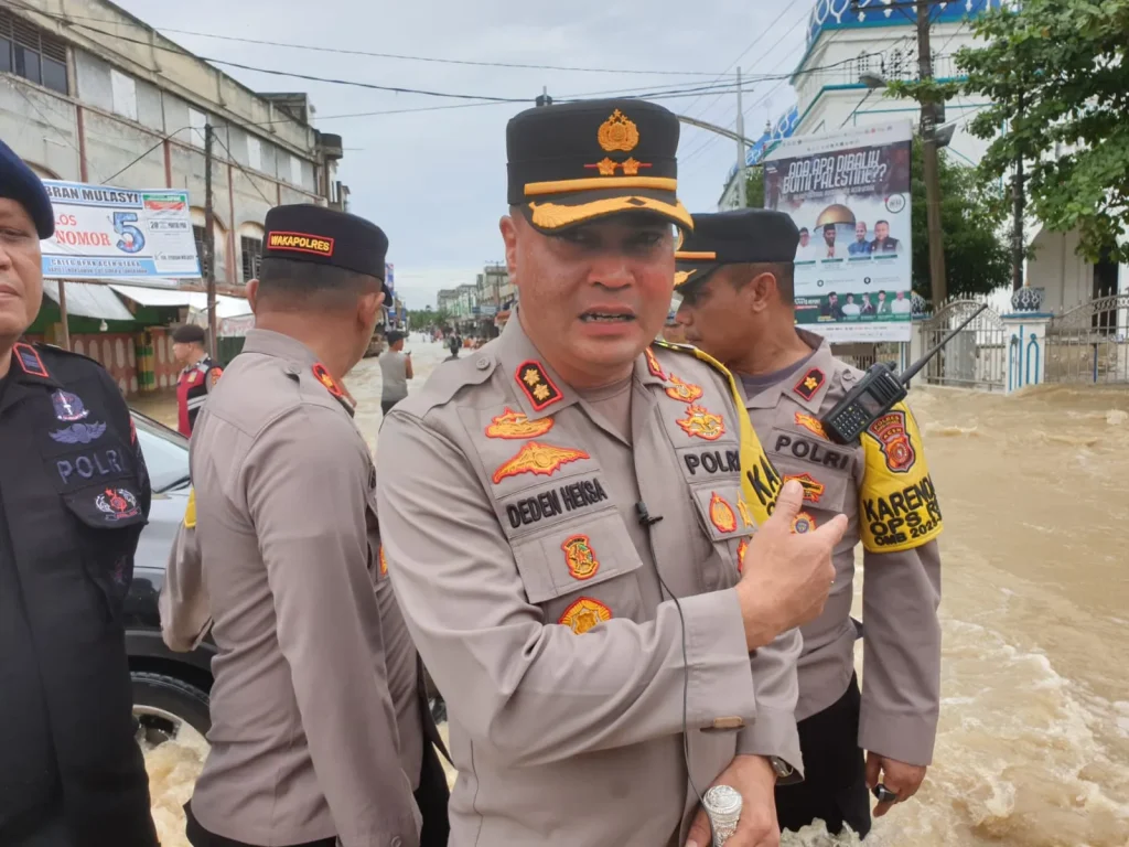 AKBP Deden Heksaputera terlibat langsung membantu warga yang melintas dengan melakukan upaya mobilisasi kendaraan yang terjebak banjir di simpang empat Kuta Lhoksukon kabupaten Aceh Utara