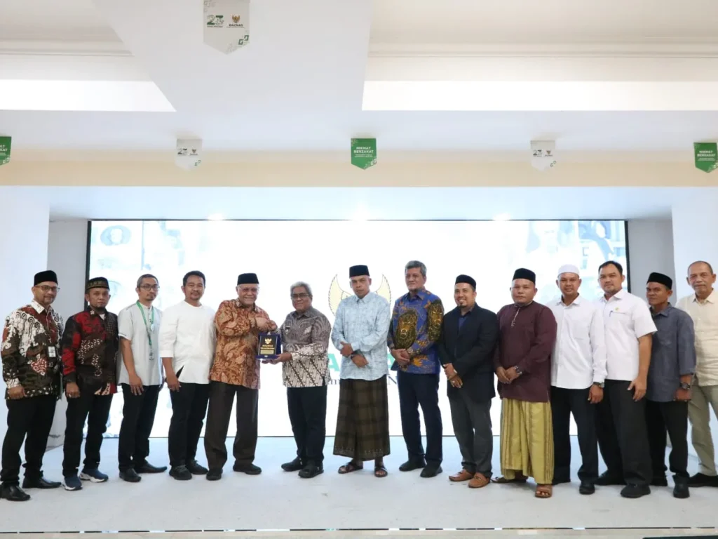 Foto: Pimpinan Baznas RI Bidang Perencanaan Kajian dan Pengembangan Prof.(HC) Dr.Zainulbahar Noor, SE, Mec memberikan cinderamata Kepada Pj Bupati Aceh Utara