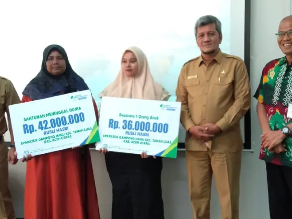 Foto: Penjabat Sekda Kabupaten Aceh Utara Dayan Albar, SSos, MAP, menyerahkan santunan kematian dan beasiswa kepada ahli waris dari keluarga aparatur gampong yang meninggal dunia.