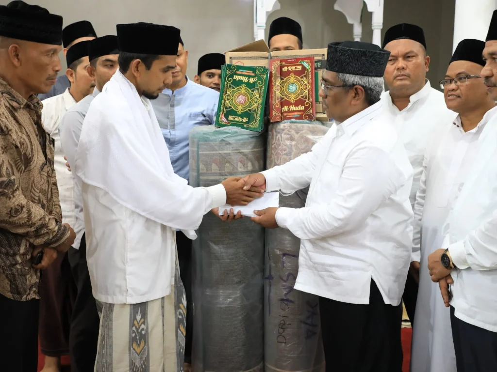 Foto: Pj Bupati Mahyuzar menyerahkan bantuan untuk Masjid Nurul Huda Matang Lada berupa sajadah panjang, kitab suci Alqur'an, dan dana pembinaan kemakmuran masjid