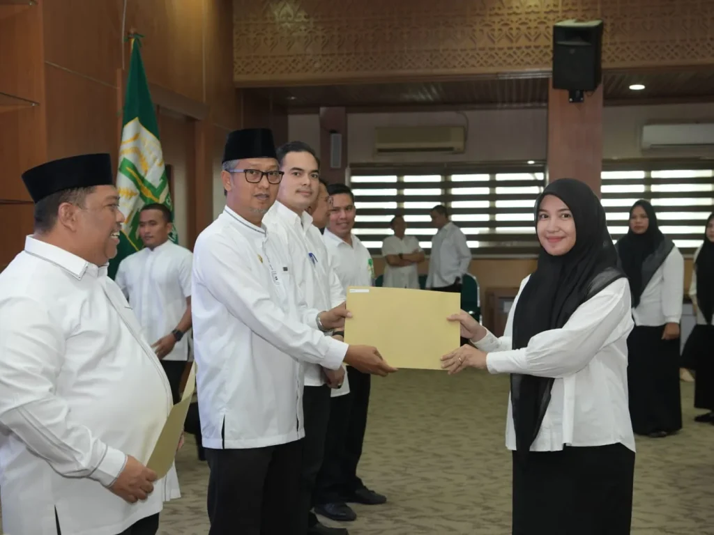 Foto: Asisten Administrasi Umum Sekda Aceh Dr. H. Iskandar AP, S.Sos. M.Si menyerahkan Sk tenaga kontrak kepada salah satu tenaga kontrak pada biro Adpim di gedung serbaguna Kantor Gubernur, Jum'at 22 Maret 2024.