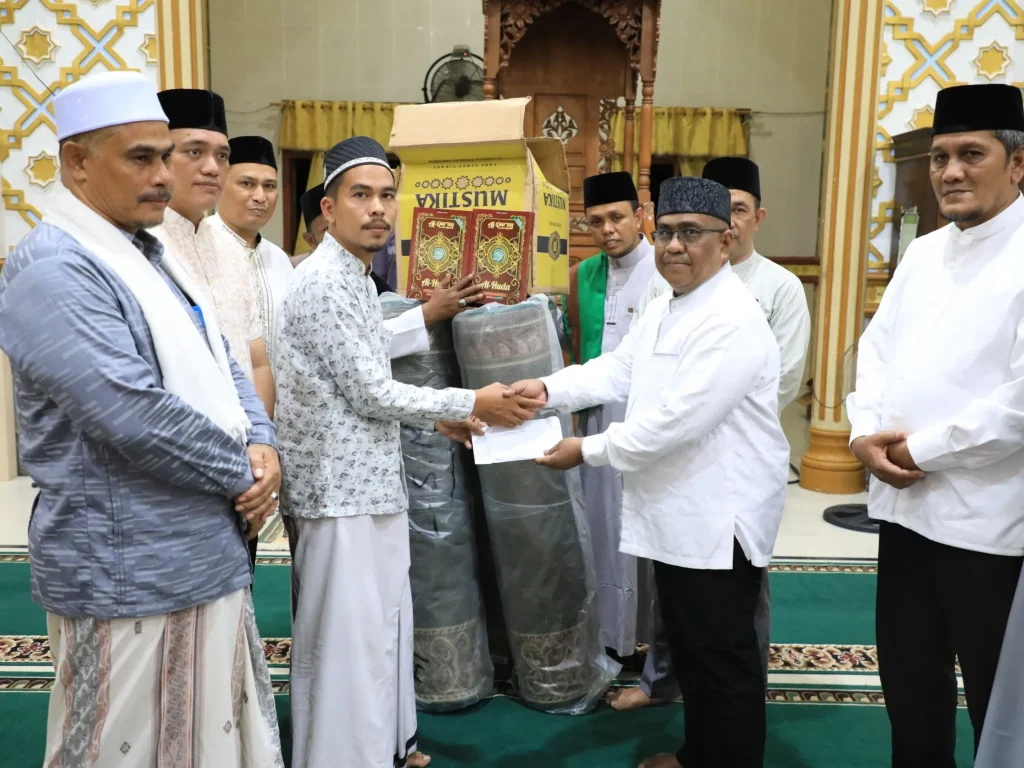 Foto: Pj Bupati Mahyuzar turut menyerahkan bantuan untuk Masjid Baitul Karim Gampong Sumbok Rayeuk berupa sajadah panjang, kitab suci Al Qur'an, dan dana pembinaan kemakmuran masjid.