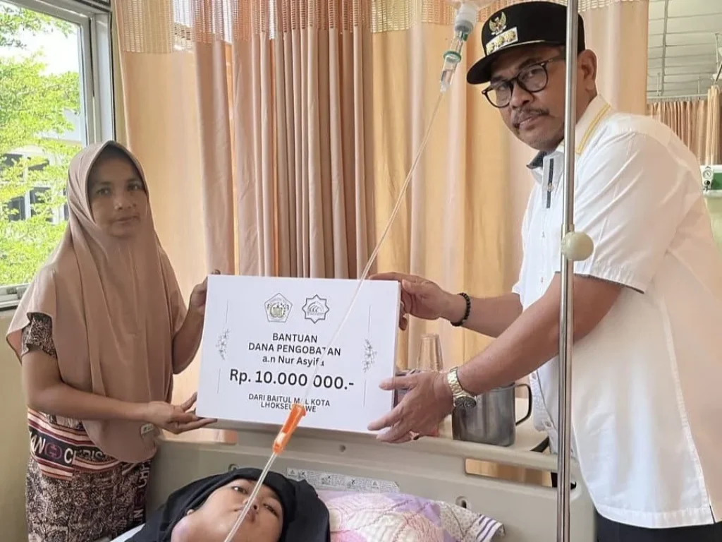 Foto: Penjabat (Pj) Walikota Lhokseumawe, A. Hanan, menyerahkan bantuan dana pengobatan kepada ananda Nur Asyifa, warga Gampong Pusong Kota Lhokseumawe yang sedang menjalani pengobatan tumor di RSUD Zainal Abidin, Banda Aceh.