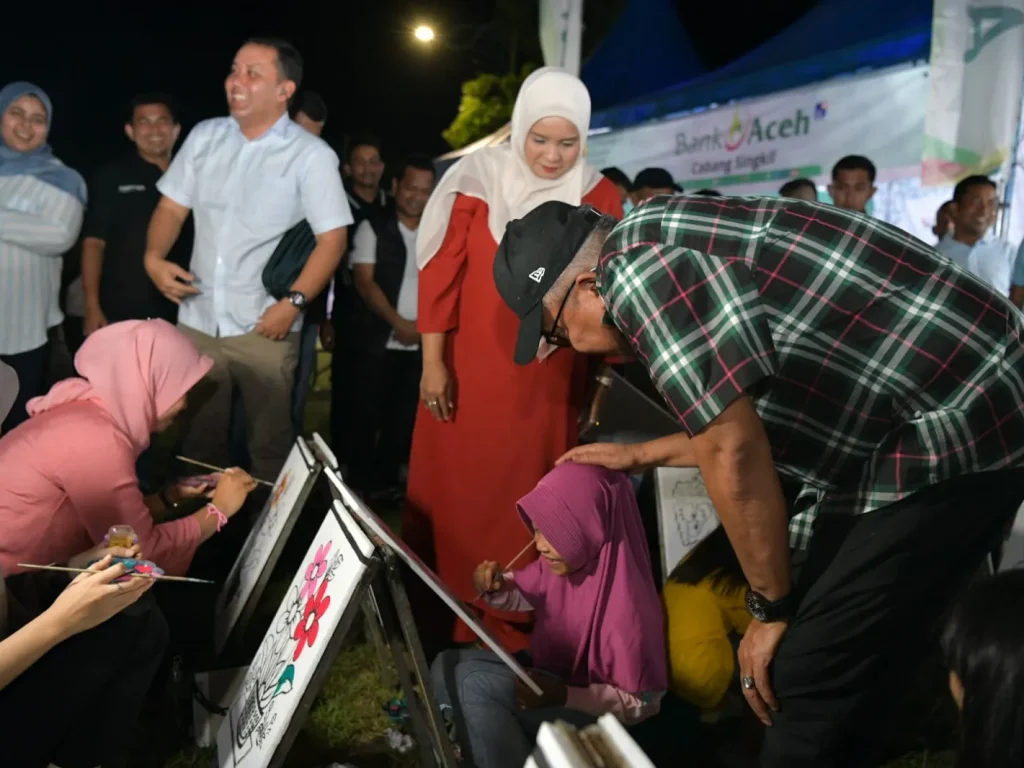 Foto: Penjabat Gubernur Aceh Bustami Hamzah dan Istri Mellani Subarni serta Ketua DPR Aceh Zulfadli dan Pj Bupati Aceh Singkikl Azmi, mentraktir es krim hingga kembang gula kepada anak-anak yang mengunjungi  arena Pagelaran Hiburan Rakyat dan Bazar UMKM, dalam rangka memeriahkan HUT Kabupaten Aceh Singkil ke-25, di Alun-Alun Kota Singkil, Sabtu (27/4/2024) malam.