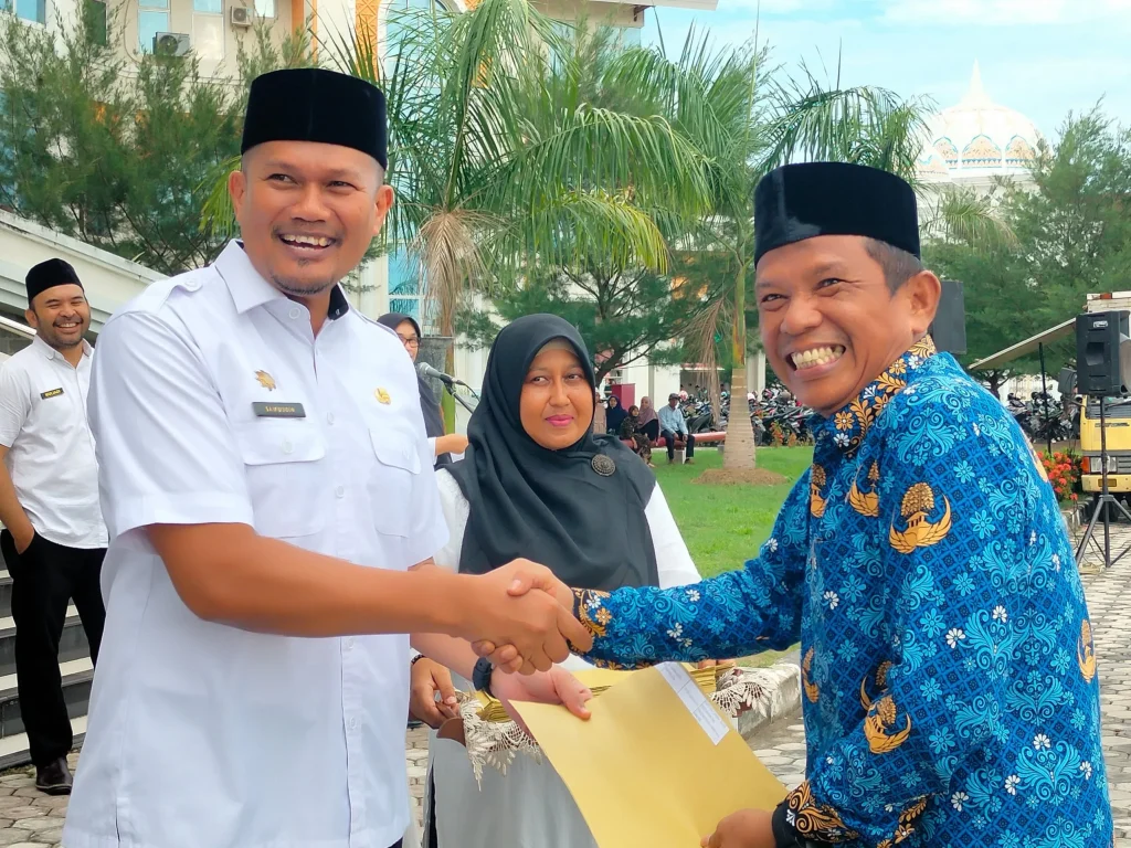 Foto: Kaban BKPSDM Aceh Utara, Saifuddin, S.STP., MSP menyerahkan SK Kepada Pegai PPPK Formasi 2023 di halaman Kantor Bupati Aceh Utara