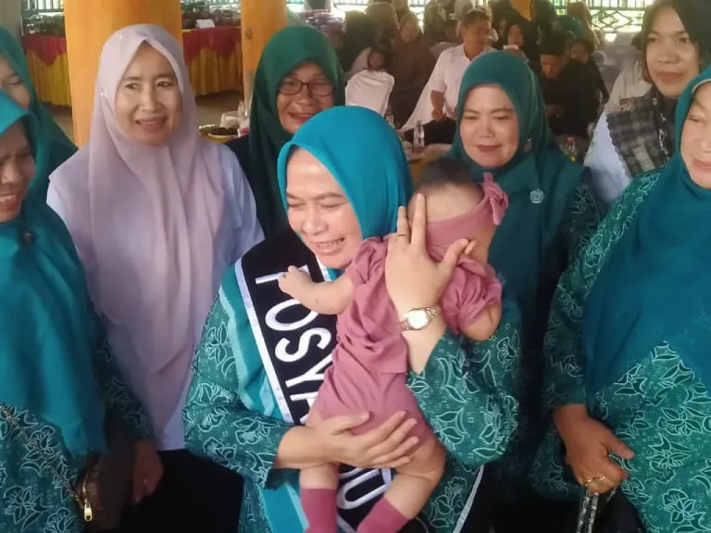 Foto: Pj Ketua TP PKK Aceh Utara Ny Awirdalina Mahyuzar, mengendong balitas usai melakukan timbang berat badan