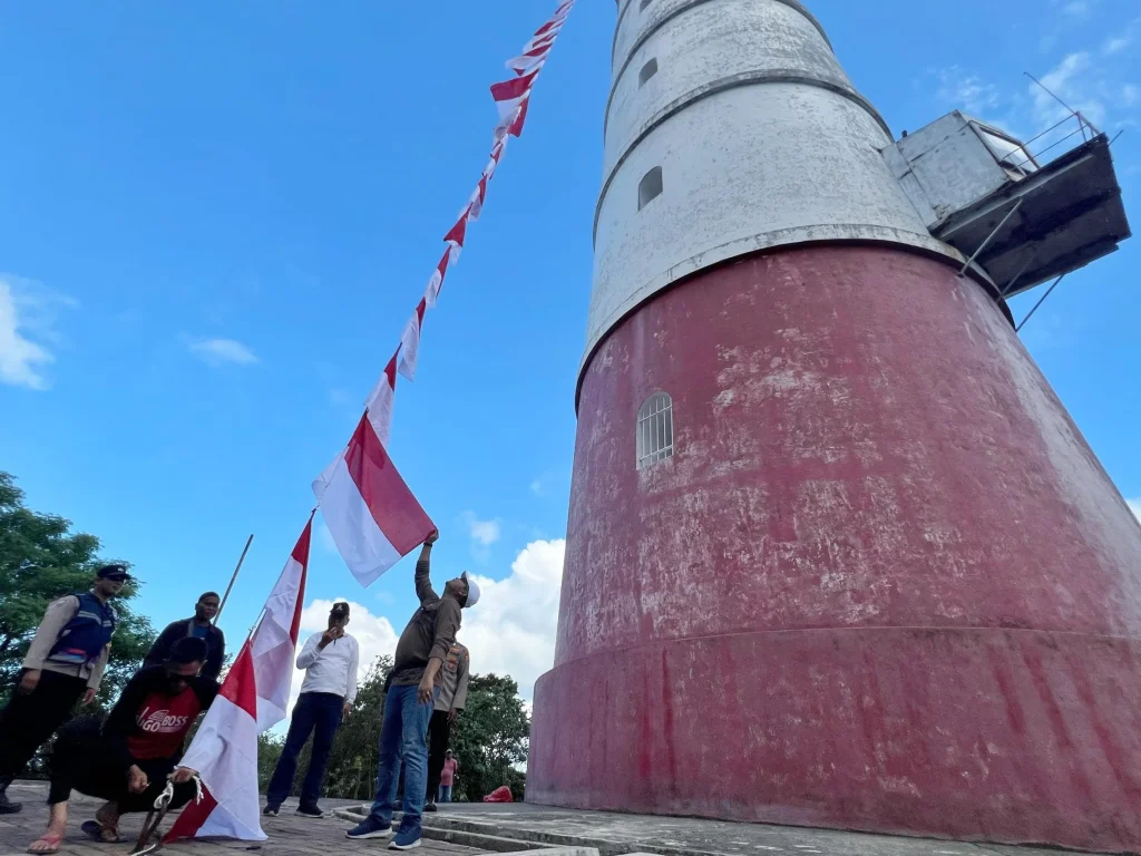 Foto: Kepala Badan Kesbangpol Aceh, Dedy Yuswadi bersama Kabid Bina Ideologi, Wawasan Kebangsaan Dan Karakter Bangsa, Munarwansyah mengibarkan Bendera Merah Putih di Mercusuar Willem's Torrent III, Pulo Breuh, Aceh Besar, Sabtu 6 Juli 2024.