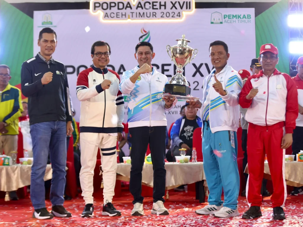 Foto: Penjabat Sekretaris Daerah Aceh, Azwardi AP, M.Si., atas nama PJ Gubernur Aceh menyerahkan piala bergilir kepada Kota Banda Aceh yang keluar sebagai juara umum  pada Pekan Olahraga Pelajar Daerah (POPDA) Aceh ke-XVII Tahun 2024, Di Gedung Idi Sport Center (ISC), Aceh Timur, Jumat, 12/7/2024.