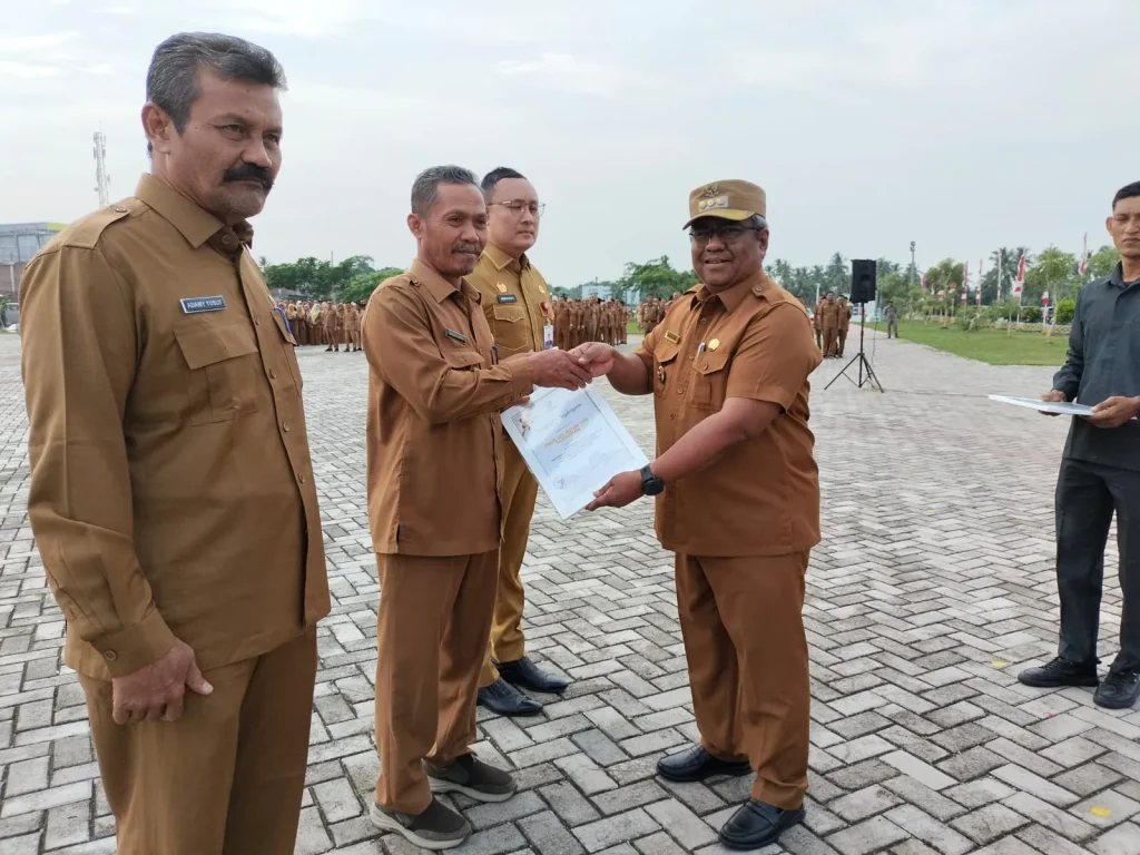 Foto: Penjabat Bupati Aceh Utara Dr Mahyuzar, MSi, menyerahkan Perhargaan kepada  tiga Organisasi Perangkat Daerah (OPD) yang memperoleh nilai tertinggi dalam evaluasi Akuntabilitas Kinerja Instansi Pemerintah (AKIP).