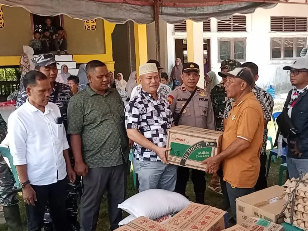 Foto: Ketua Komisi IV DPRA, H. Ismail A. Jalil, SE., MM. (Ayah Wa) menyerahkan bantuan Kepada Masyarakat Gampong  Lhok Pu'uk yang diterima Geuchik setempat