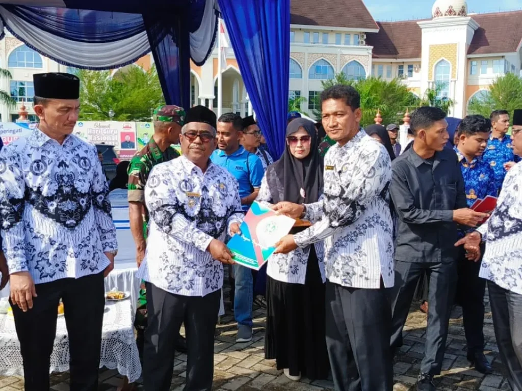 Foto: Penjabat Bupati Dr Mahyuzar, MSi menyerahkan penghargaan kepada insan pendidikan