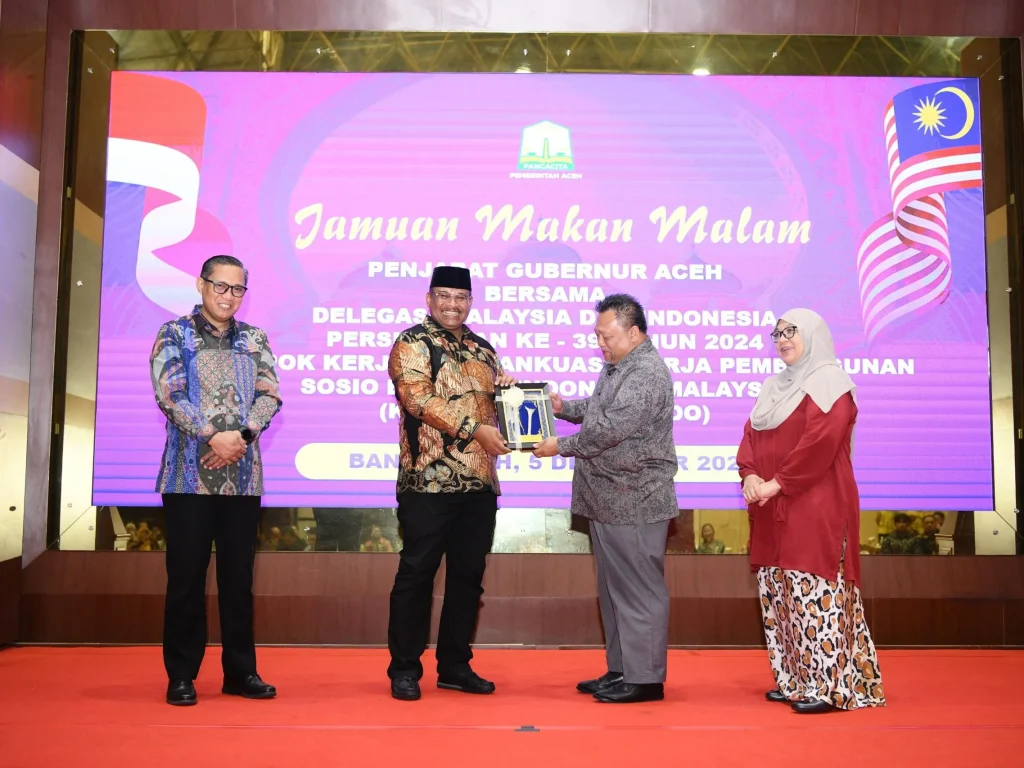 Foto:  Dr H Safrizal ZA M Si, selaku Dirjen Bina Administrasi Kewilayahan Kemendagri mewakili Delegasi Indonesia dan Encik Hamzah bin Ishak selaku Ketua Delegasi Malaysia, menandatangani Risalah KK/JKK Sosek Malindo ke-39, di ruang tengah Meuligoe Gubernur Aceh, Jum'at (6/12/2024) dini hari